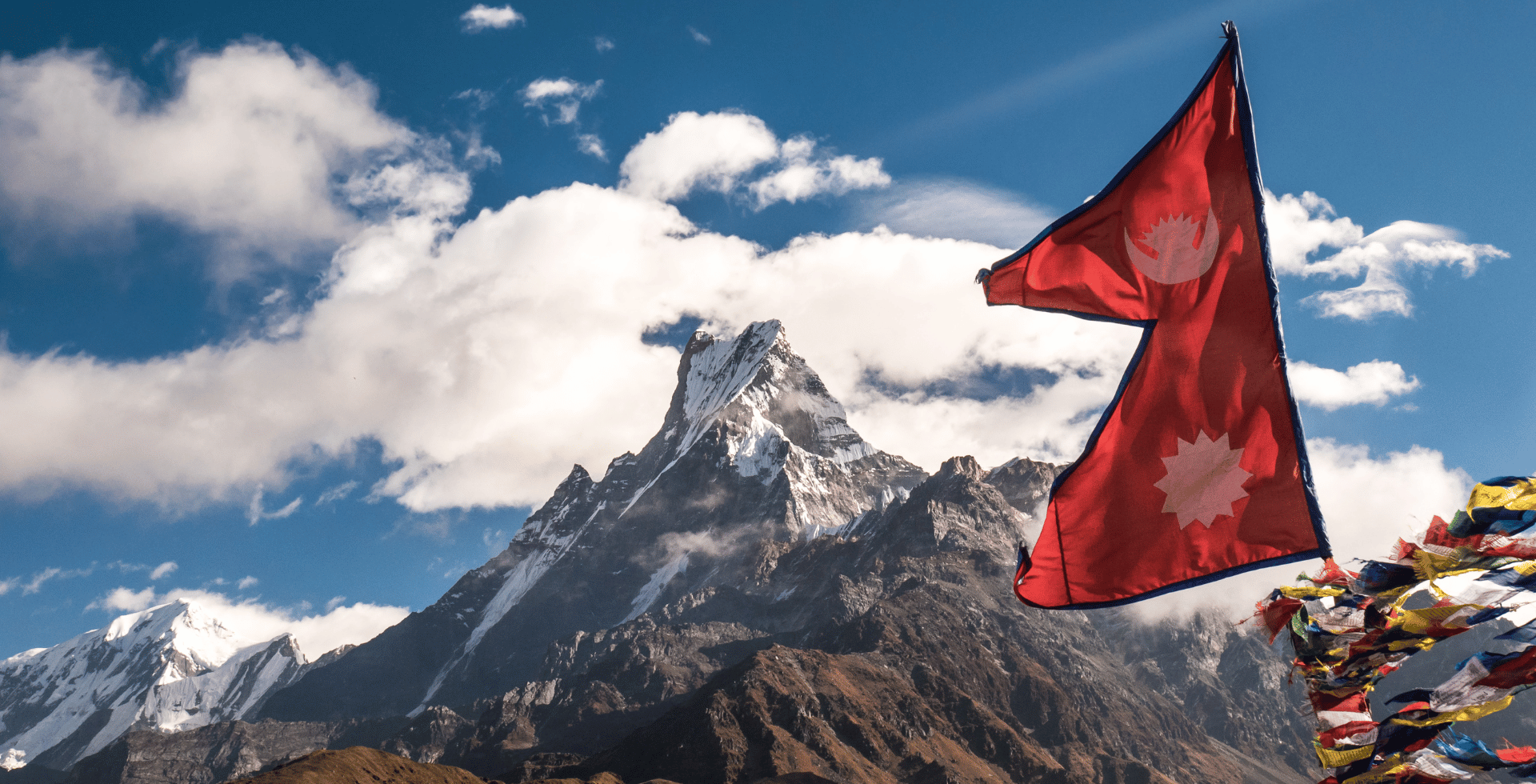 flag of nepal fluttering with mt. machhapurchre in the background