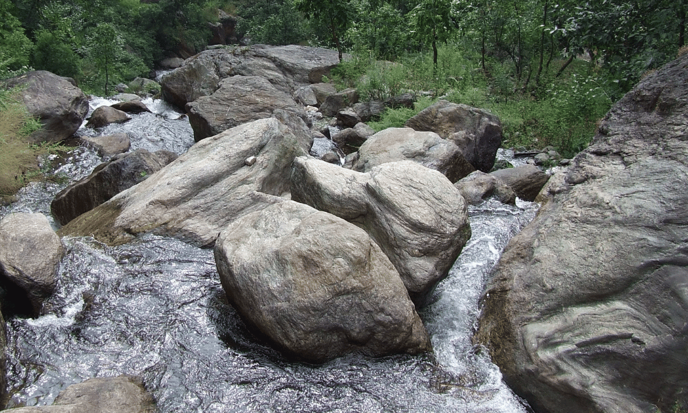 stones and shallow river in annapurna trail