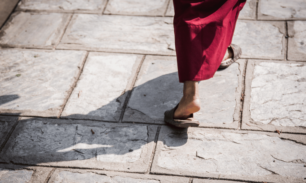 monk walking on stone pavement