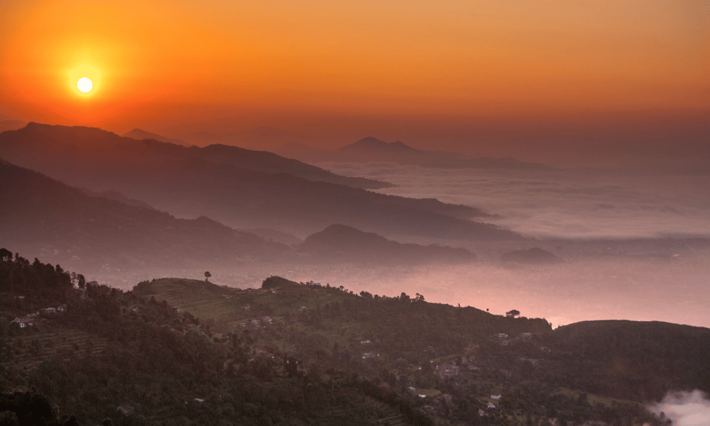 sunrise view from sarangkot, pokhara with hills surrounding and fog covering the valley