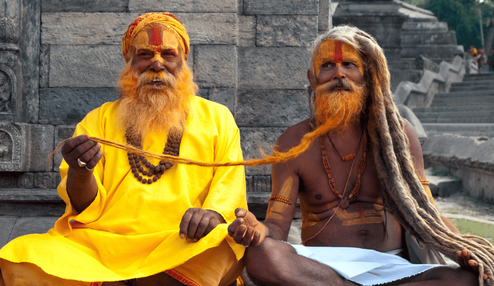 Sadhu Baba smiling and pulling at each other's beard