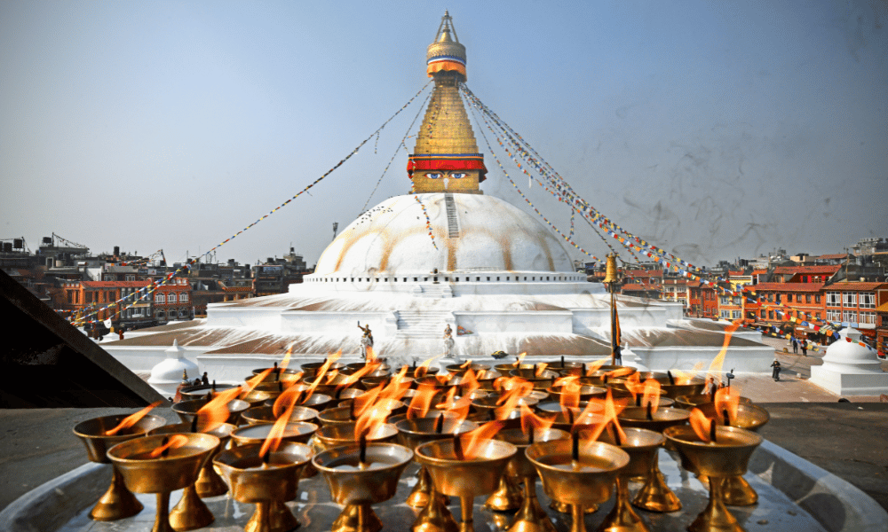 boudhanath stupa with a tray of oil lamps infront of it